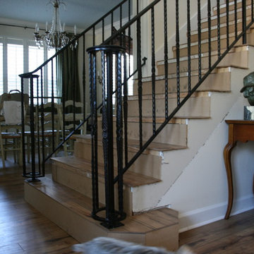 Interior ornamental stair rail with hammered pickets and lateral scroll ending