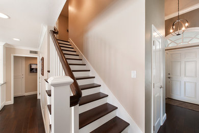 Inspiration for a large transitional wooden straight wood railing staircase remodel in Orange County with painted risers