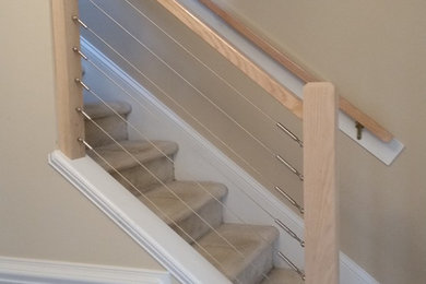 Small minimalist carpeted straight cable railing staircase photo in Raleigh with carpeted risers
