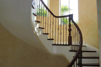 Example of a large classic wooden spiral wood railing staircase design in Albuquerque with painted risers