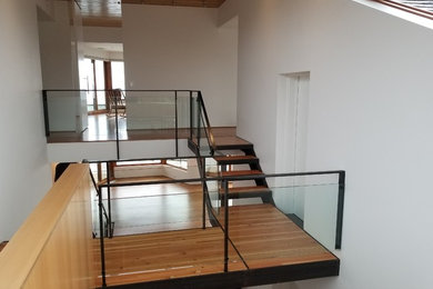 Réalisation d'un escalier minimaliste avec un garde-corps en verre.