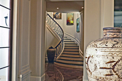 Ejemplo de escalera curva tradicional de tamaño medio con escalones de madera y contrahuellas de madera pintada