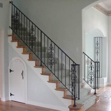 Interior wrought iron stair rail and column cover with lateral scroll ending