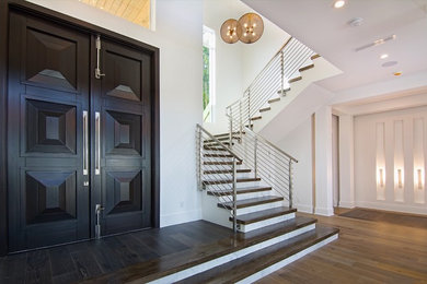 Ejemplo de escalera en U minimalista grande con escalones de madera, contrahuellas de madera pintada y barandilla de cable