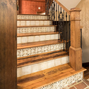 Modelo de escalera en U, ecléctica, con escalones de madera, contrahuellas con baldosas y/o azulejos y barandilla de varios materiales