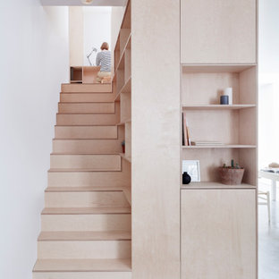 Photo of a modern wood straight staircase in London with wood risers.