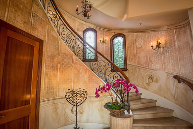 Staircase - huge mediterranean marble curved mixed material railing staircase idea in Los Angeles with marble risers