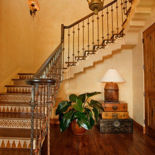 Modelo de escalera en L, mediterránea, grande, con escalones de madera, contrahuellas con baldosas y/o azulejos y barandilla de varios materiales