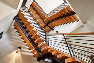Ejemplo de escalera en L minimalista grande sin contrahuella con escalones de madera