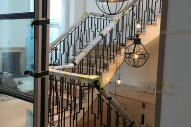 Expansive modern spiral metal railing staircase in London with limestone treads and limestone risers.