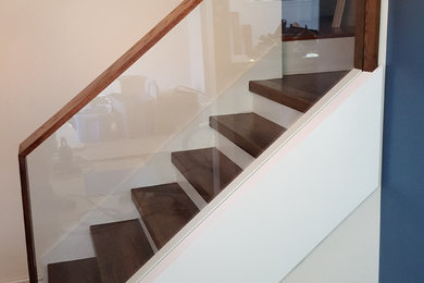 他の地域にあるコンテンポラリースタイルのおしゃれな直階段 (ガラスフェンス) の写真