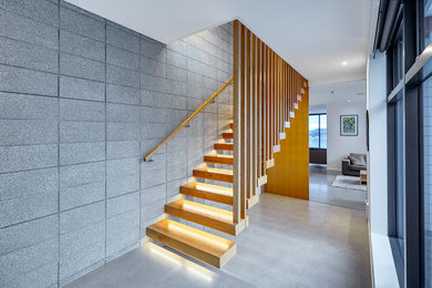 Imagen de escalera suspendida contemporánea de tamaño medio sin contrahuella con escalones de madera y barandilla de madera