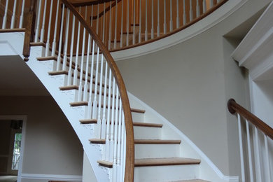 Inspiration for a large timeless wooden curved staircase remodel in DC Metro with painted risers
