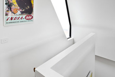 Cette image montre un petit escalier design en U avec des marches en bois.