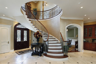 Diseño de escalera en U tradicional grande con escalones de madera, contrahuellas de madera pintada y barandilla de metal