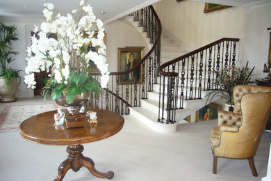 This is an example of a medium sized traditional curved staircase in Channel Islands.