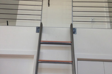 Foto de escalera recta industrial de tamaño medio con escalones de madera, contrahuellas de madera y barandilla de metal