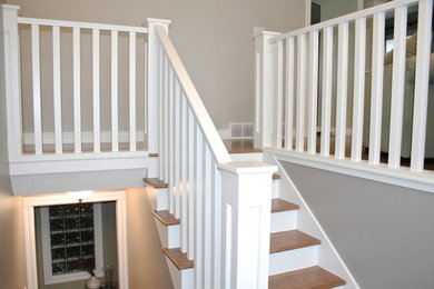 Ejemplo de escalera en U tradicional de tamaño medio con escalones de madera y contrahuellas de madera pintada
