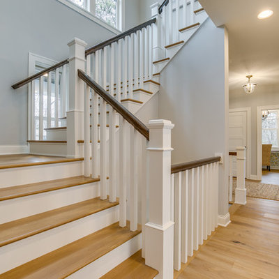 Example of a mid-sized farmhouse wooden u-shaped wood railing staircase design in Minneapolis with painted risers