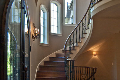Ejemplo de escalera curva clásica con escalones de madera y contrahuellas de madera
