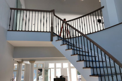 Staircase - mid-sized traditional wooden curved mixed material railing staircase idea in Tampa with wooden risers