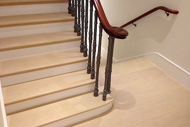 Ejemplo de escalera recta clásica con escalones de madera, contrahuellas de madera y barandilla de madera