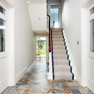 Inspiration for a contemporary painted wood u-shaped wood railing staircase in London with painted wood risers.