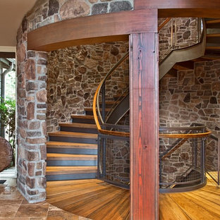 Esempio di una grande scala curva rustica con pedata in legno