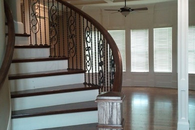 Staircase - mid-sized modern wooden curved metal railing staircase idea in Atlanta with painted risers