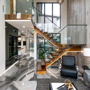 Photo of a contemporary wood staircase in Sydney with open risers and glass railing.
