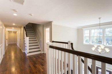 Huge transitional wooden straight staircase photo in New York with painted risers
