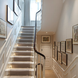 Classic painted wood u-shaped wood railing staircase in London with painted wood risers.