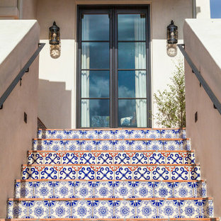 Diseño de escalera exterior, mediterránea, con contrahuellas con baldosas y/o azulejos, escalones de terracota y barandilla de metal