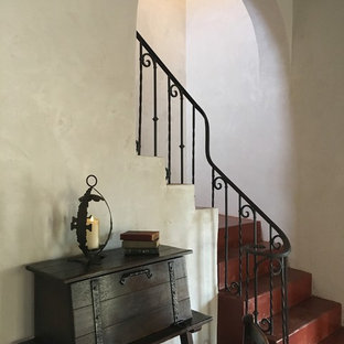Immagine di una grande scala a "L" american style con pedata in cemento, alzata in cemento e parapetto in metallo