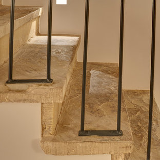 Idee per una grande scala a rampa dritta chic con pedata in pietra calcarea, alzata in pietra calcarea e parapetto in metallo