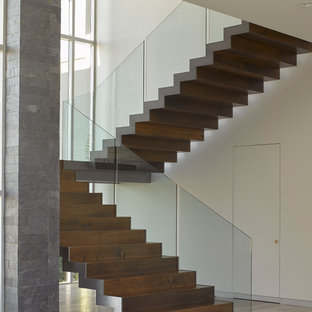 Idee per una grande scala sospesa contemporanea con pedata in legno, alzata in legno e parapetto in vetro