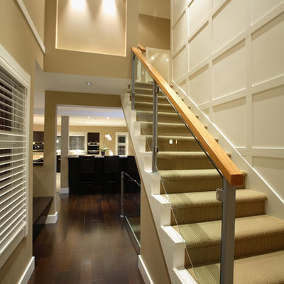 Large transitional painted straight glass railing staircase photo in Vancouver with painted risers