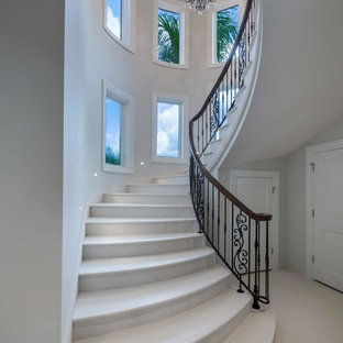 Esempio di un'ampia scala curva mediterranea con pedata in travertino, alzata in travertino e parapetto in materiali misti