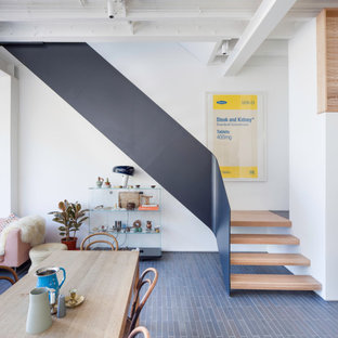 Inspiration for a contemporary wood metal railing staircase in London with open risers.