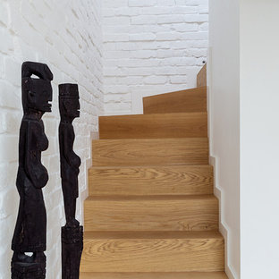 Cette photo montre un petit escalier courbe industriel avec des marches en bois et des contremarches en bois.