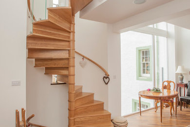 This is an example of a contemporary wood spiral staircase in Other with wood risers and feature lighting.