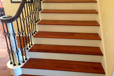 Staircase - large mediterranean wooden curved staircase idea in San Diego with painted risers