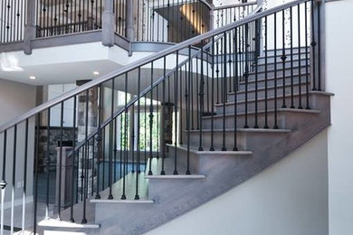 Modelo de escalera curva minimalista grande con escalones de madera, contrahuellas de madera y barandilla de varios materiales