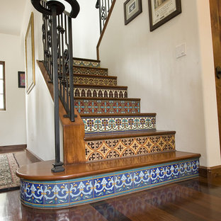 Mediterranean wood staircase in Los Angeles with tiled risers.