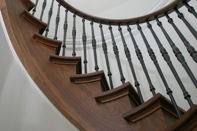 Idée de décoration pour un escalier courbe tradition de taille moyenne avec des marches en bois et des contremarches en bois.