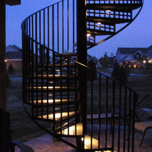 Aménagement d'un petit escalier hélicoïdal contemporain avec des marches en bois, des contremarches en métal et un garde-corps en métal.