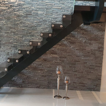 Metal spine stairs with glass balustrade and 10 cm thickness treads