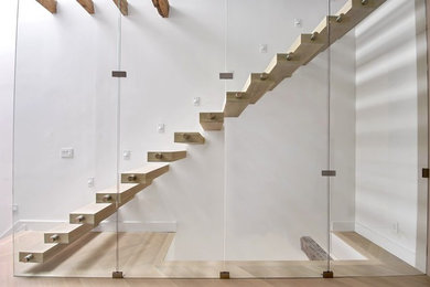 Large minimalist wooden straight open and metal railing staircase photo in New York