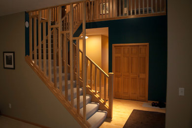 Diseño de escalera en L tradicional grande con escalones enmoquetados, contrahuellas enmoquetadas y barandilla de madera