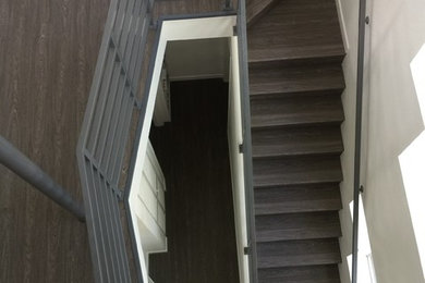 Foto de escalera en L contemporánea de tamaño medio con escalones de acrílico y barandilla de metal